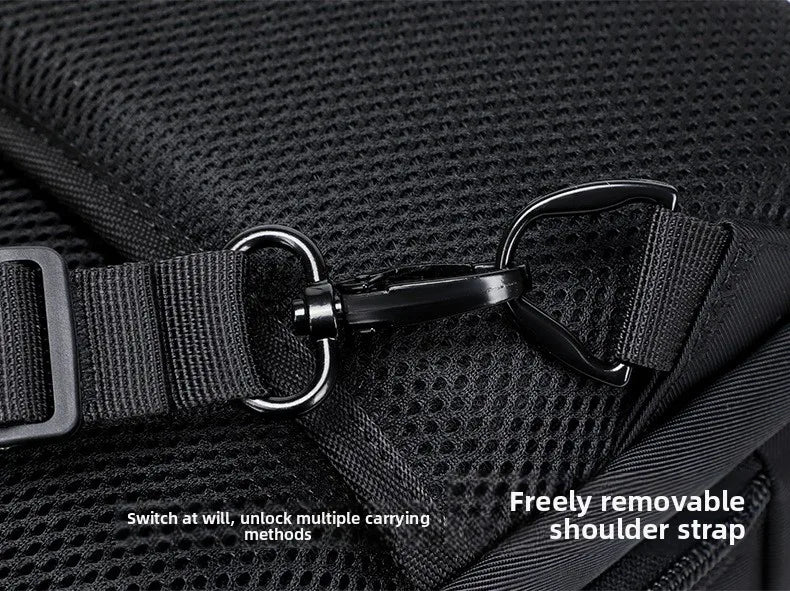 Close-up of a black travel sling bag showing the durable metal clip for the adjustable, removable shoulder strap.