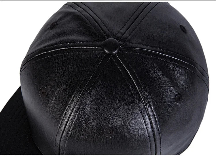 Close-up of a black faux leather baseball cap with a classic six-panel design, top button and stitched seams.