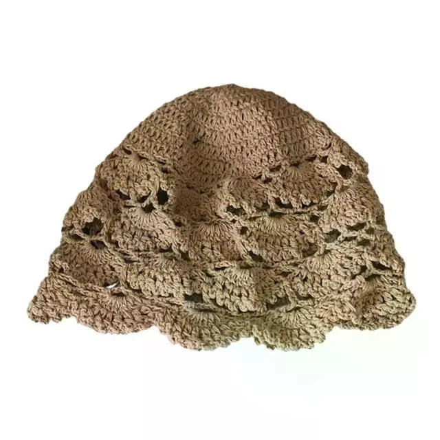 Beige crochet bucket hat with a decorative hollow lace pattern and a scalloped edge.
