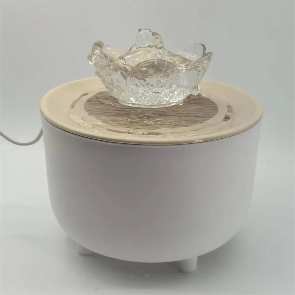 White, circular pet water fountain with a tan top and a clear, lotus-shaped flower fountain head.