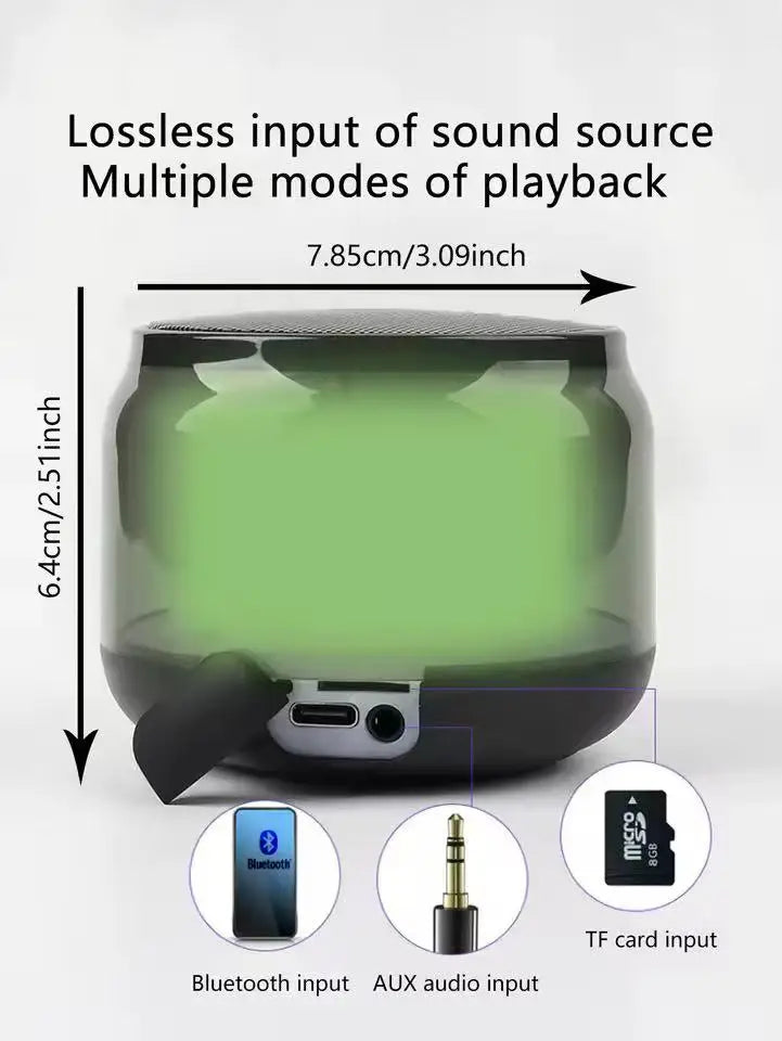 Compact dark green, transparent portable wireless speaker with Bluetooth, AUX and TF card inputs. Measures 7.85x6.4cm.