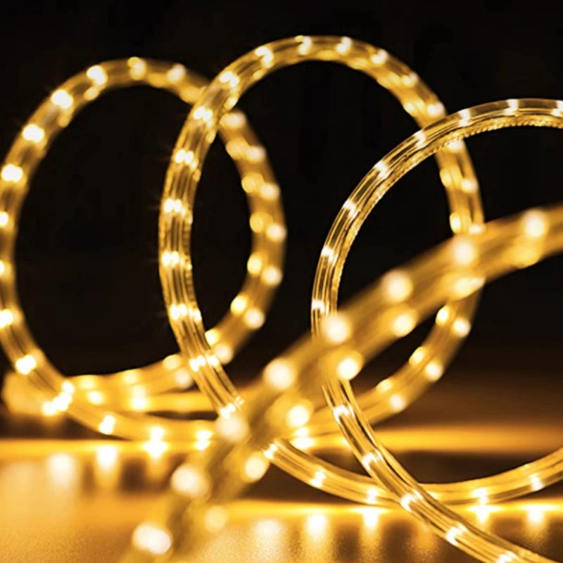 A coil of warm white flexible LED rope lights glowing against a dark background.