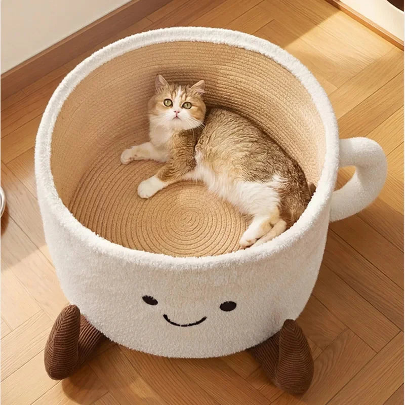 White coffee-cup shaped cat bed with a beige rope interior, smiling face, handle, and brown feet, holding a cat.