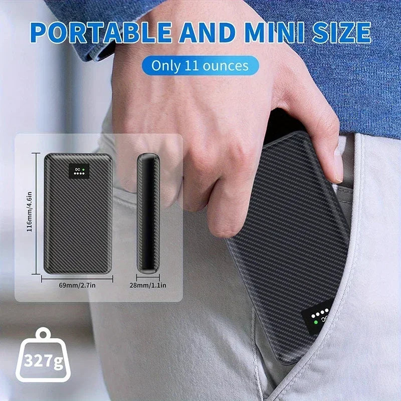 Compact, black carbon-fibre effect portable power bank for heated clothing, easily fitting into a trouser pocket.