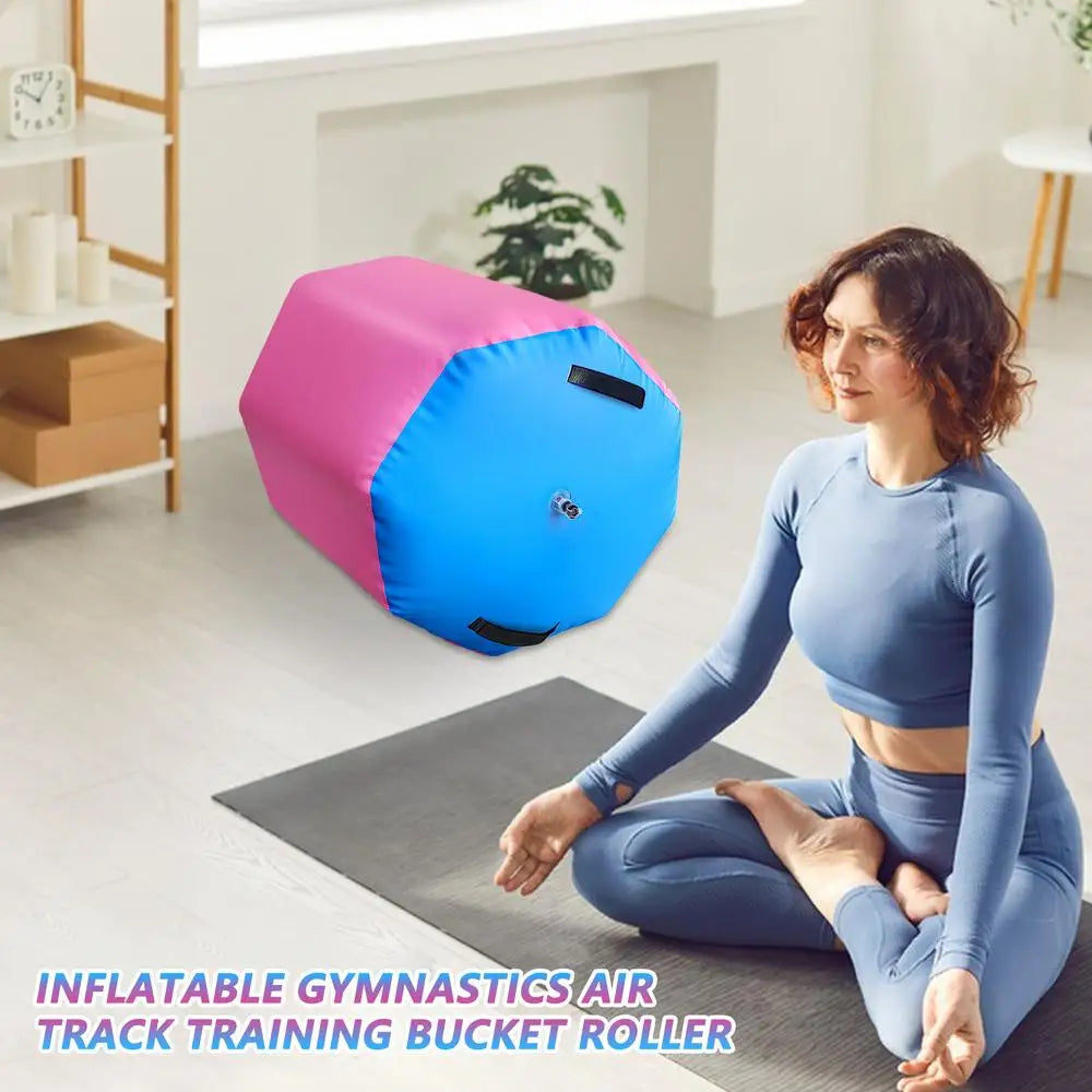 Inflatable pink and blue gymnastics air roller barrel with black carry handles and a central inflation valve.