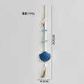 Boho wall hanging featuring white beads, blue wooden accents, a large blue seashell charm and a natural jute tassel.