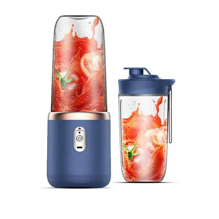 Portable navy blue blender with a clear cup containing tomato juice and a matching lid with a carry loop.