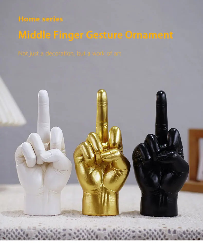 Three hand gesture ornaments in white, gold, and black finishes, featuring a modern middle finger sculpture design.