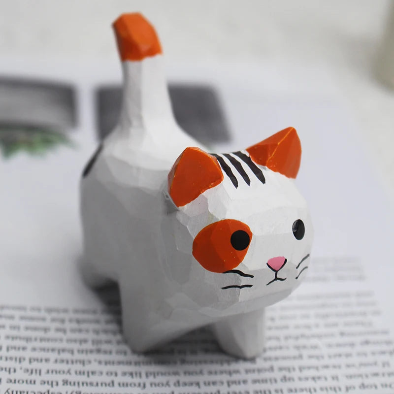 Hand-carved wooden cat ornament with a white body, orange tail, and cute painted face.