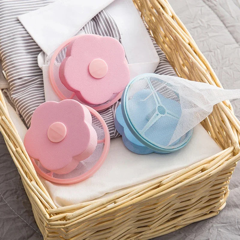 Two pink and one blue flower-shaped laundry lint catcher bags inside a wicker laundry basket.