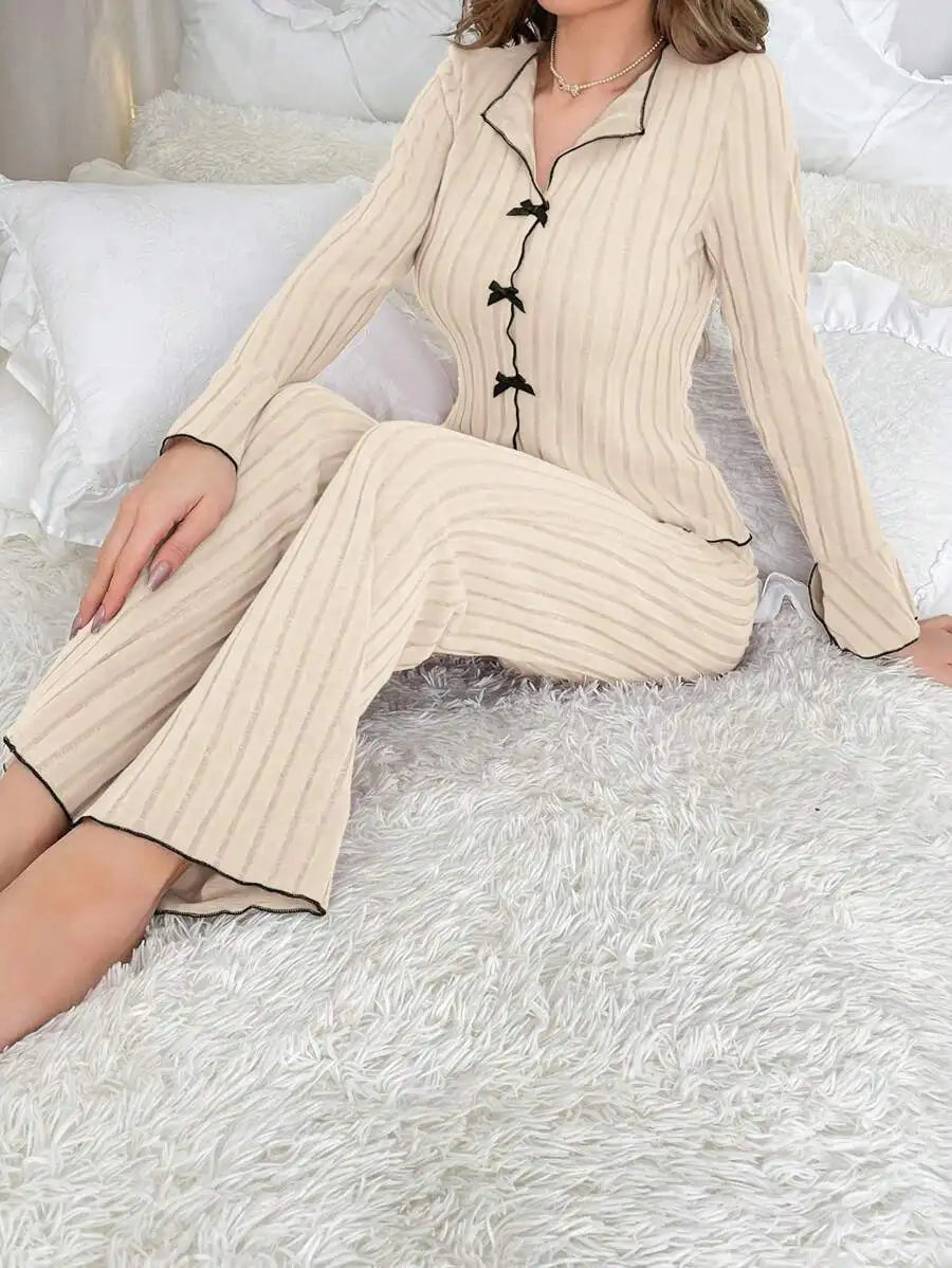 Beige ribbed loungewear set with a button-up top, black contrast piping, and decorative bow details.