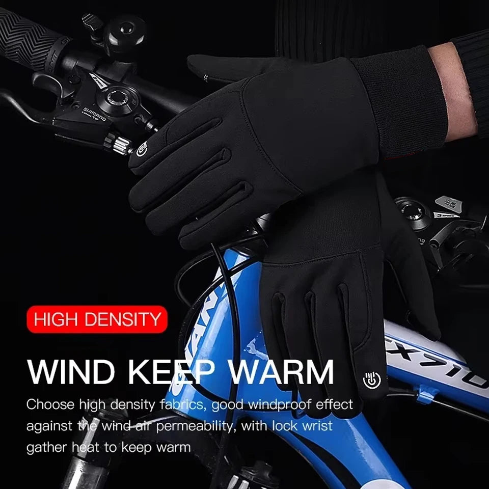 Black touchscreen-compatible cycling gloves with ribbed cuffs, held over a blue bicycle frame.