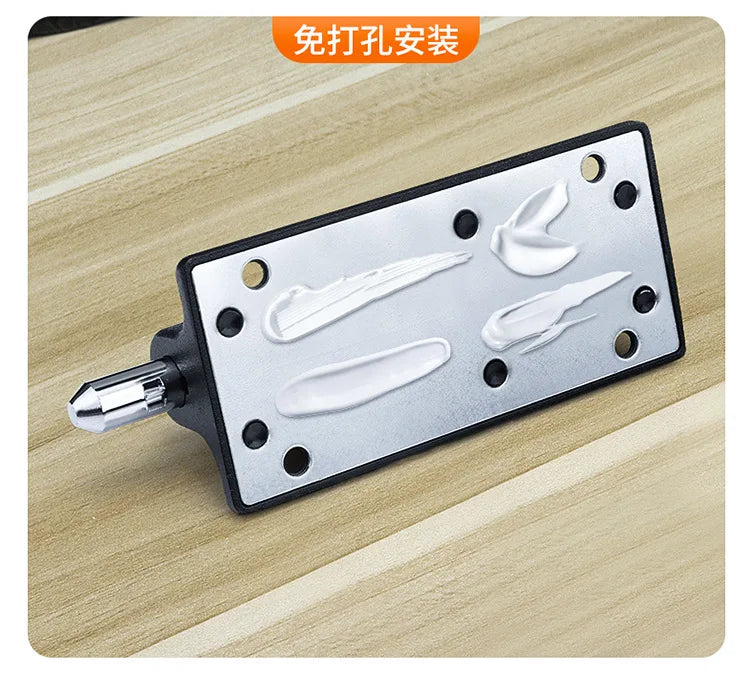 Black and silver metal adhesive mounting plate for wall fixtures, showing dots of white mounting adhesive.