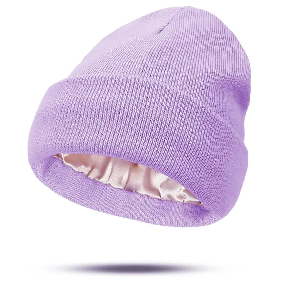 Lilac knitted beanie with a smooth, pale pink satin lining and a folded cuff.