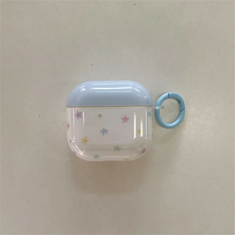 Clear AirPods case with pastel star pattern, blue top, and matching carabiner ring. Compatible with AirPods.