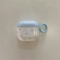 Clear AirPods case with pastel star pattern, blue top, and matching carabiner ring. Compatible with AirPods.