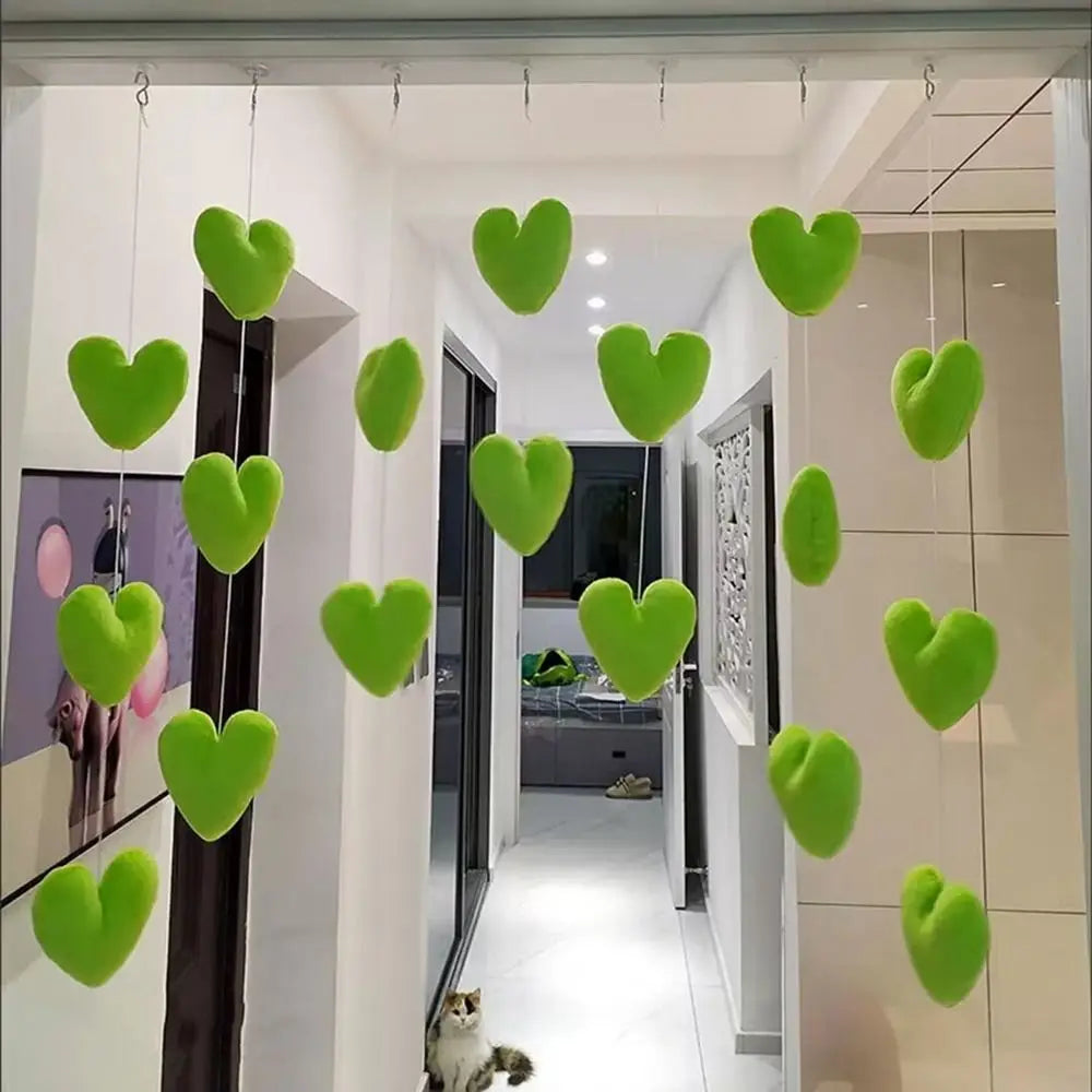 Decorative hanging room divider featuring strings of plush, lime green heart ornaments.