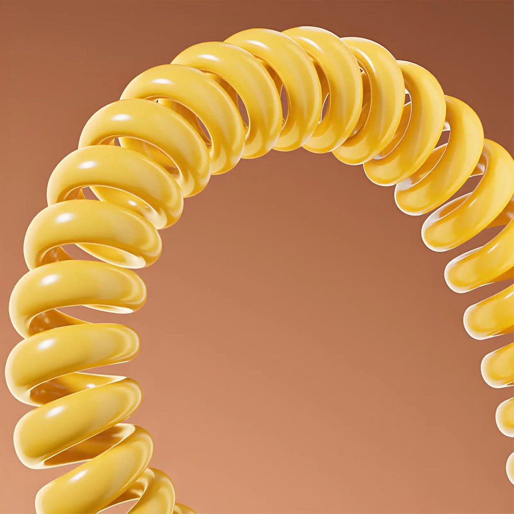 A glossy, bright yellow coiled fitness resistance rope curved against a solid tan background.