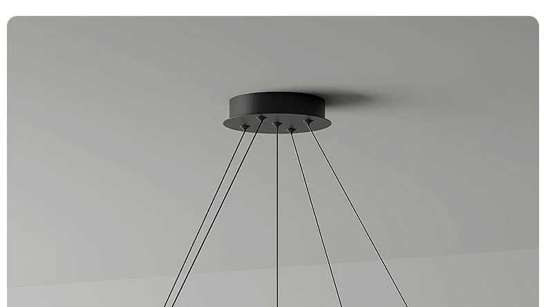 Minimalist matte black circular ceiling mount for a multi-pendant light fitting against a plain grey ceiling.
