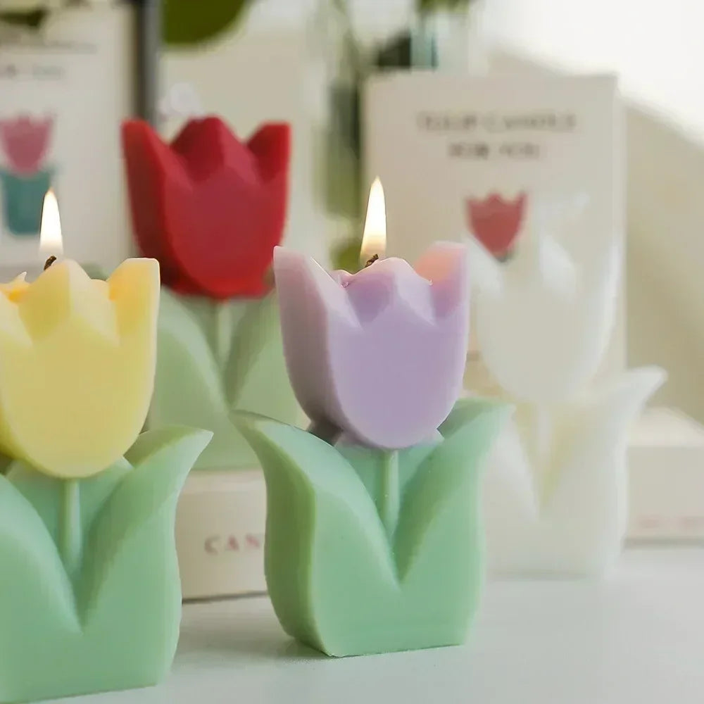 Group of decorative, burning tulip-shaped candles in pastel yellow, purple, red, and white with green leaf bases.