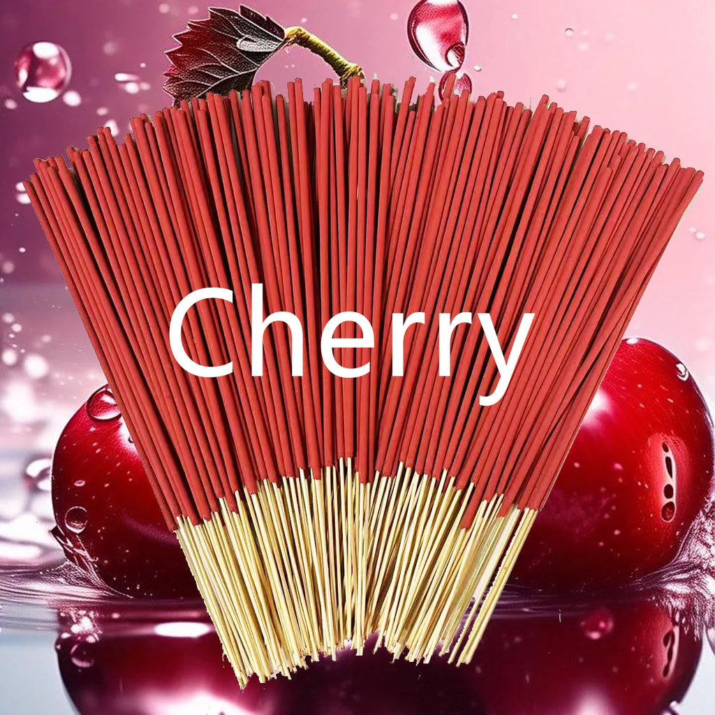 A fanned bunch of red cherry-scented incense sticks with wooden bases, set against a background of glossy cherries.