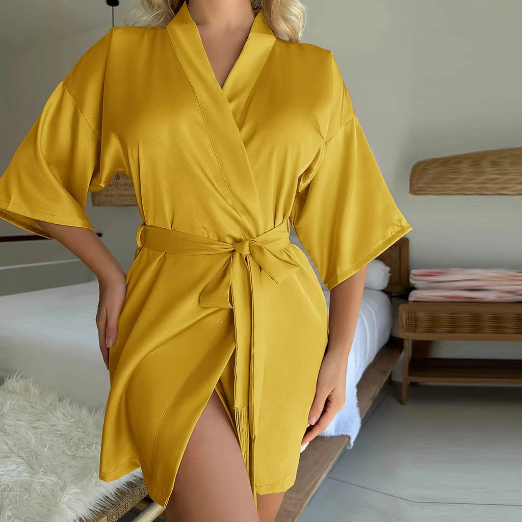 Mustard yellow satin short robe with wide sleeves, a tie-waist belt, and a wrap-front style.