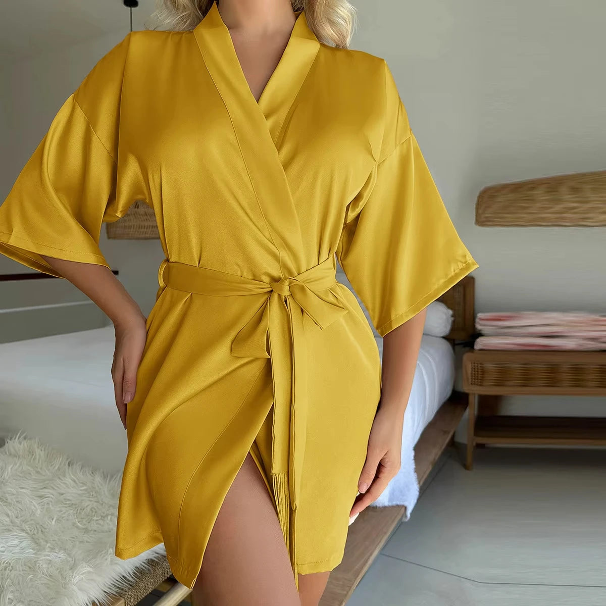 Mustard yellow satin short robe with wide sleeves, a tie-waist belt, and a wrap-front style.