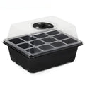 Black 12-cell plastic seedling tray with a clear, vented domed lid for starting seeds on a white background.