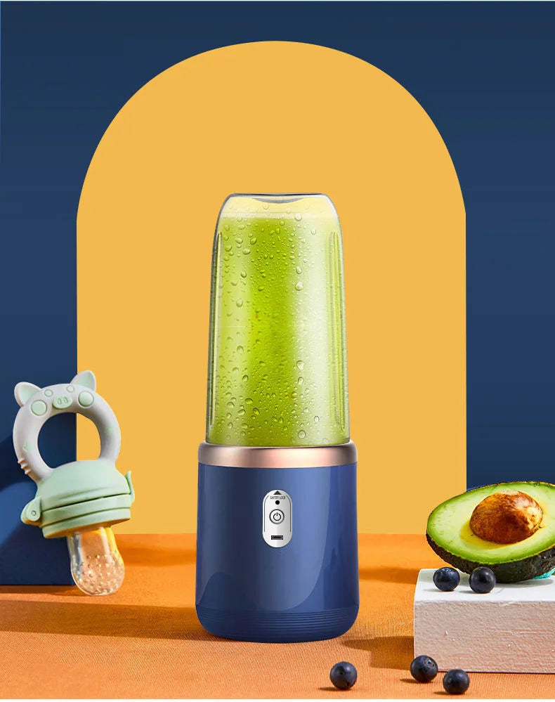 Portable blue electric blender filled with green smoothie, next to a baby food feeder and half an avocado.
