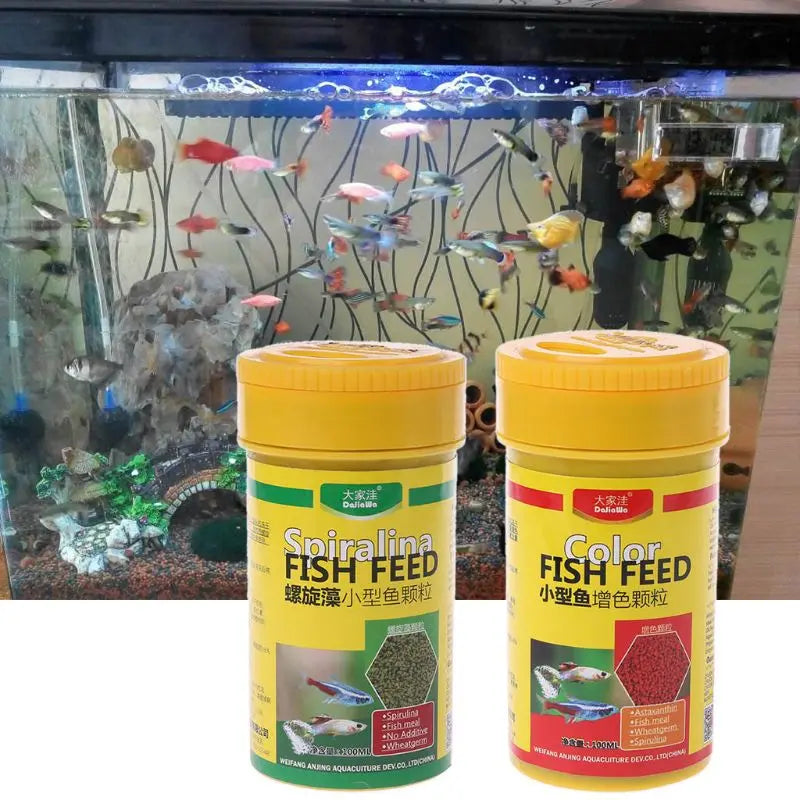 Two yellow bottles of nutrient-rich Spirulina and Colour fish food granules placed in front of a busy home aquarium.