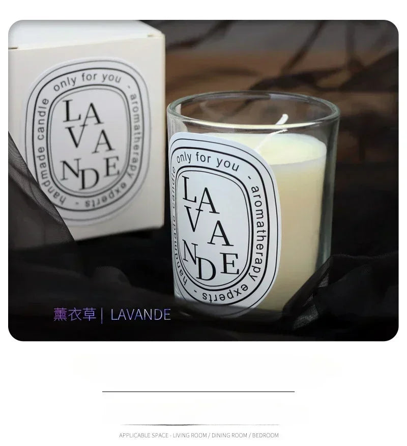 Creamy white aromatherapy candle in a glass jar, featuring an oval label, with matching gift box and black fabric base.