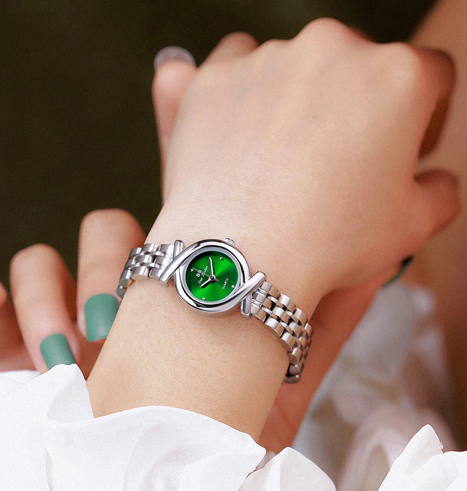 Women's silver-tone stainless steel quartz watch with a round green sunray dial and a crossover-style bracelet.