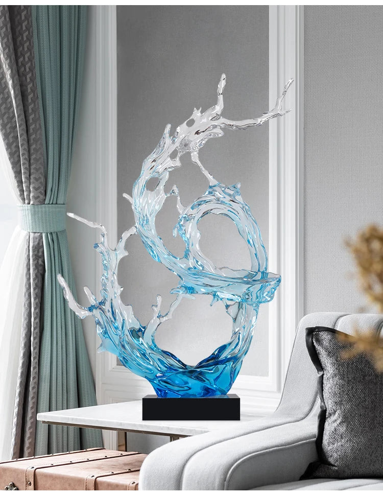 A modern, clear and blue resin ornament featuring an abstract, flowing water-splash design on a black rectangular base.
