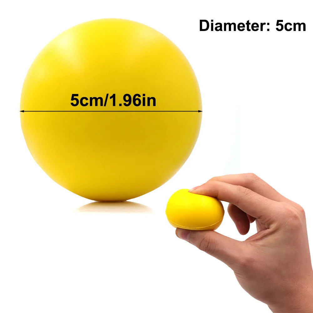 A hand squeezes a small, bright yellow 5cm stress ball against a white background.