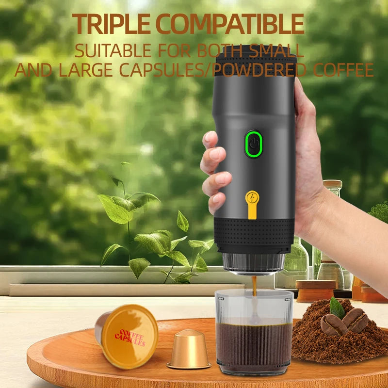 A hand holds a portable, dark gray coffee maker, dispensing coffee into a cup on a wooden tray with two capsules and coffee grounds.