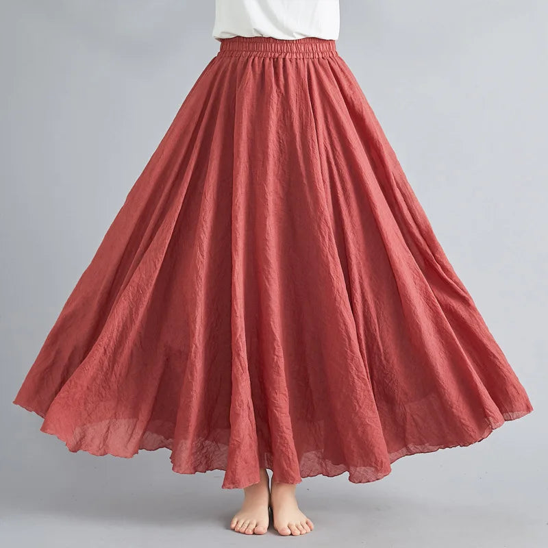 A flowy, rust-red maxi skirt with an elasticated waistband and a crinkled, lightweight texture.