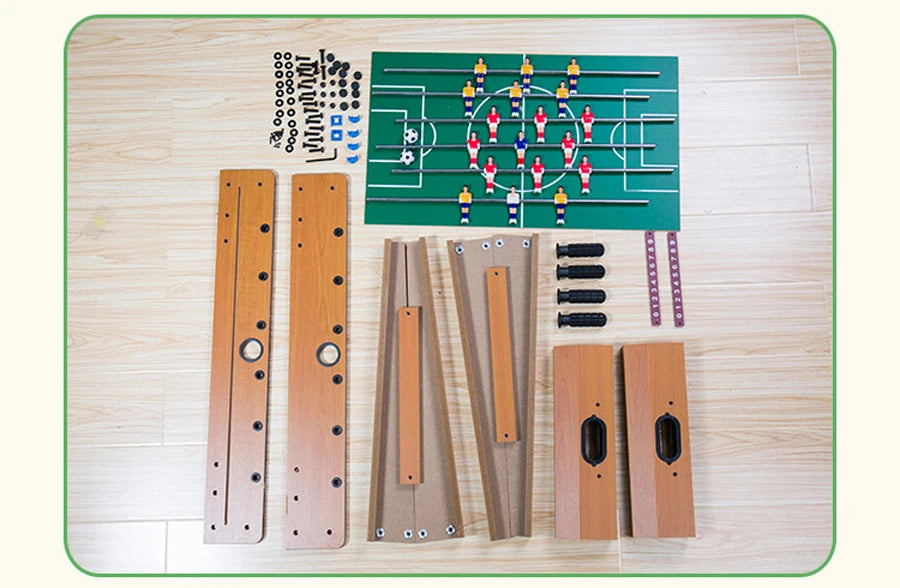 Flat-pack table football set with wooden frame panels, green pitch, players, assembly hardware, and score trackers.