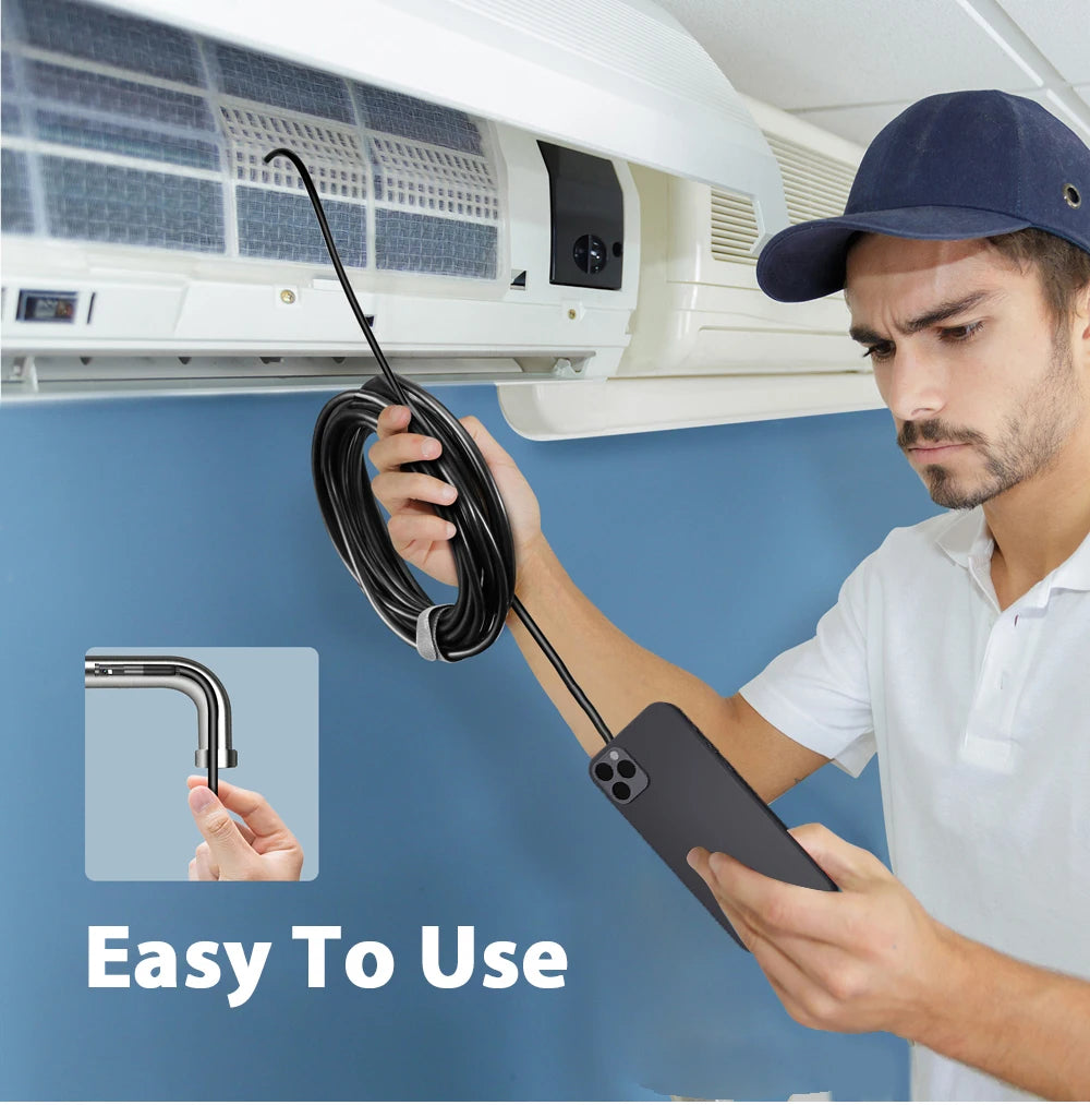 A technician using a black flexible inspection camera connected to a smartphone to check an air conditioning unit.
