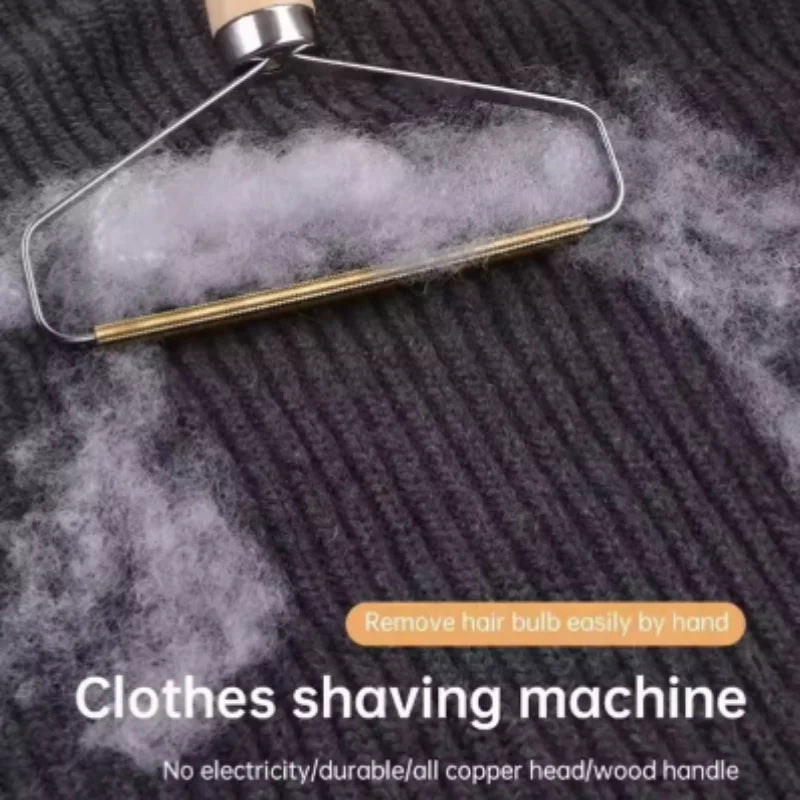 A portable clothes lint remover with a wooden handle and copper head, shown removing fluff from a grey knitted jumper.