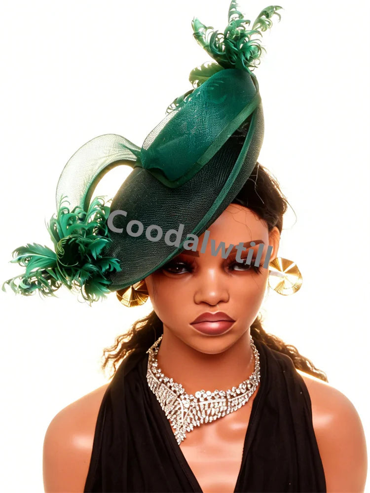 Elegant emerald green fascinator with sculptural mesh detailing and decorative feathers, worn on a mannequin.