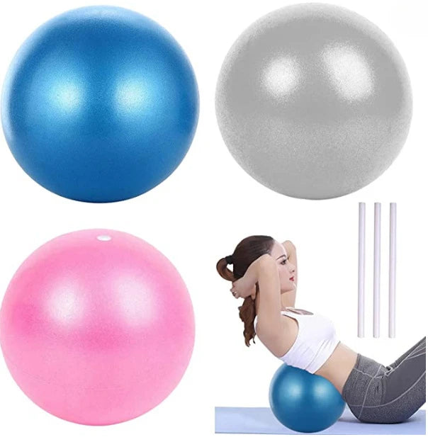 Three exercise balls in blue, silver, and pink, with a woman exercising on the blue ball.