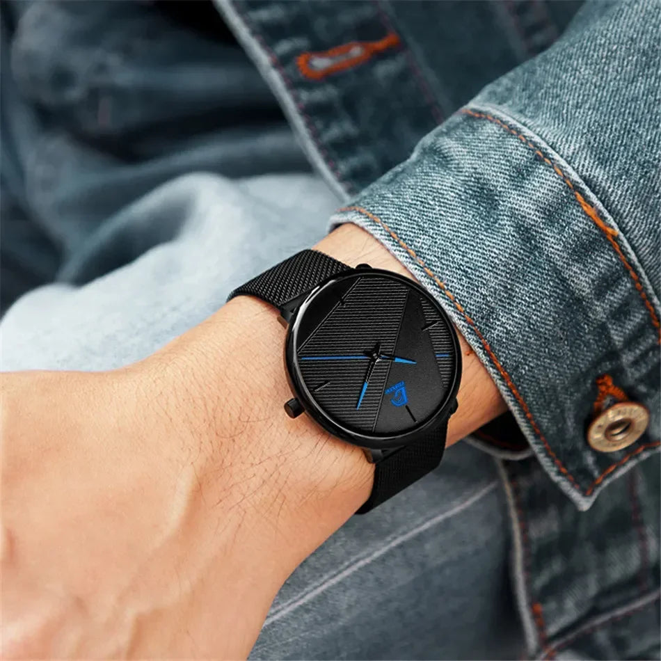 Minimalist ultra-thin men’s watch with a black mesh strap and textured black dial featuring blue accent hands.