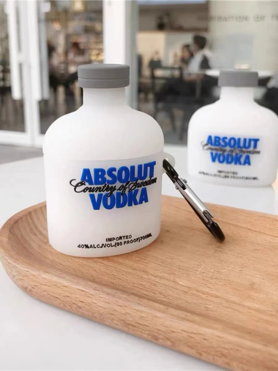 White silicone AirPods case shaped like an Absolut Vodka bottle with a grey cap and black carabiner attachment.