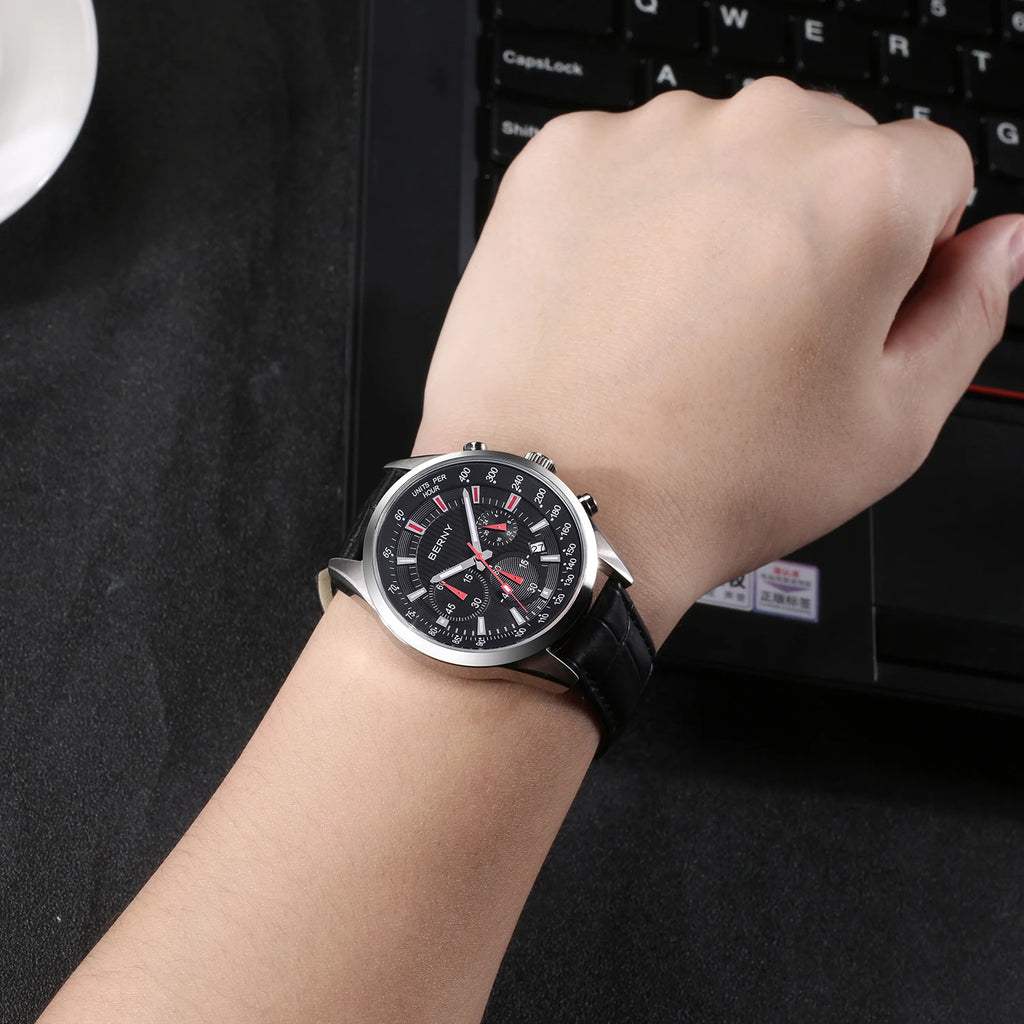 BERNY men's chronograph watch with round silver case, black dial, red accents, and black leather strap worn on wrist.