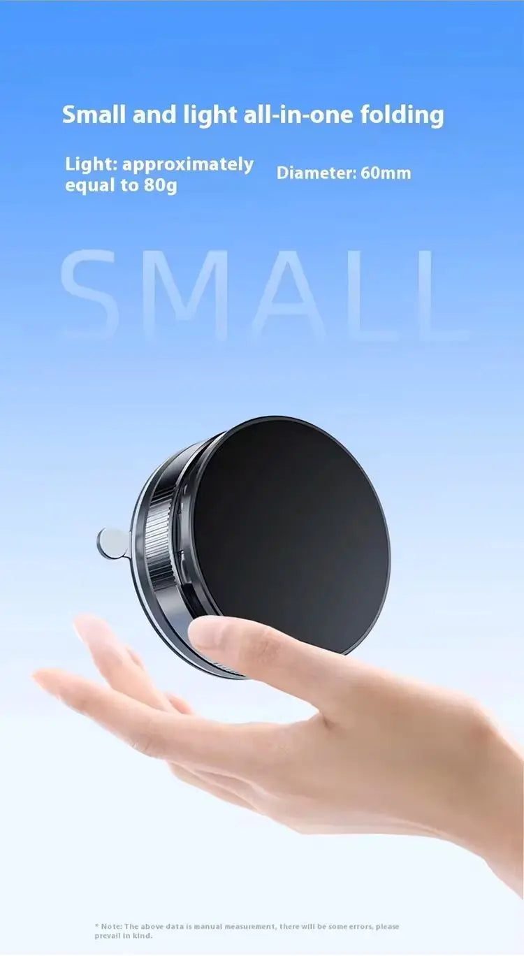 Hand holding a small, round, black and silver folding device against a light blue background.