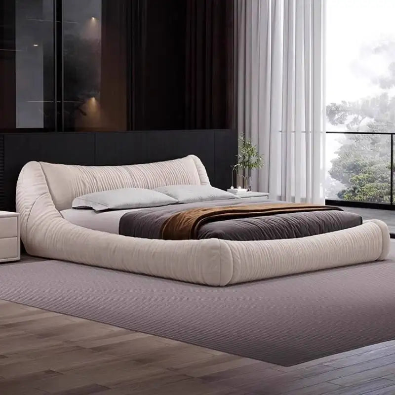 Modern cream fabric bed frame with a curved, tufted design and low-profile silhouette in a contemporary bedroom.
