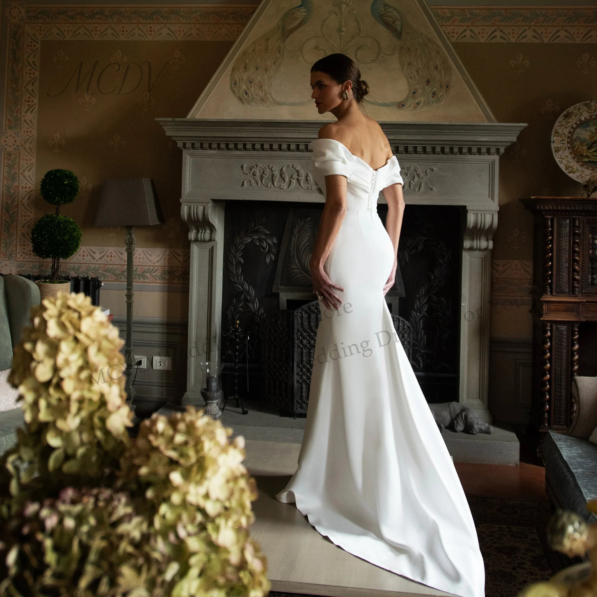 White off-shoulder satin mermaid wedding dress with sweetheart neckline and fitted silhouette.