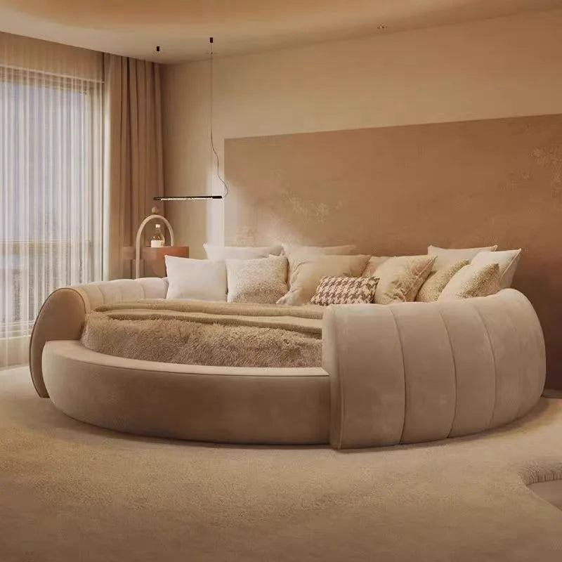 Modern minimalist circular beige bedside table in a plush, neutral bedroom setting.