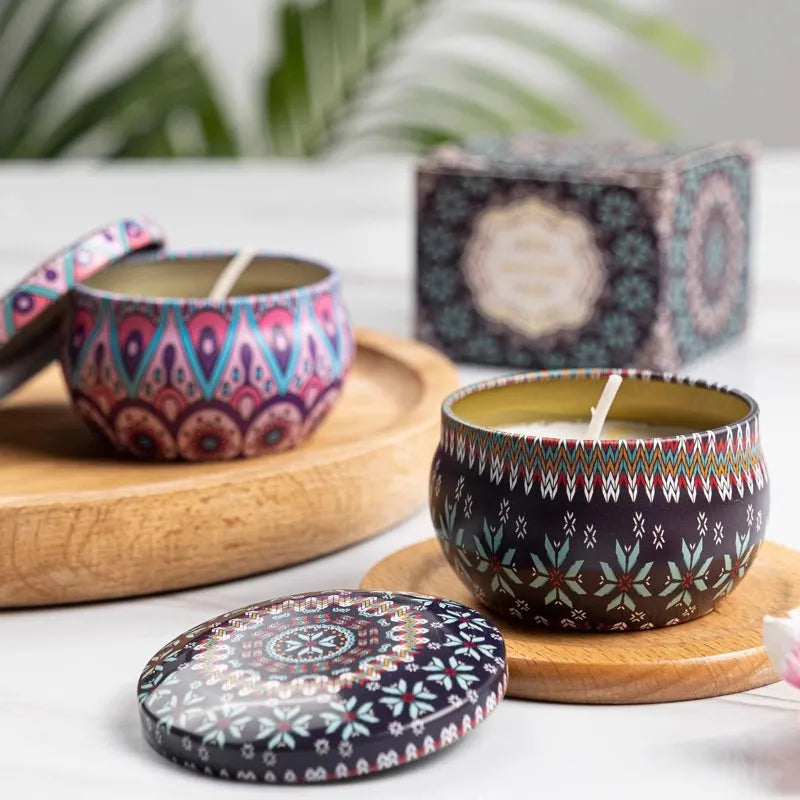 Two decorative tin candles featuring colourful, intricate boho-style patterns, each with a matching removable lid.