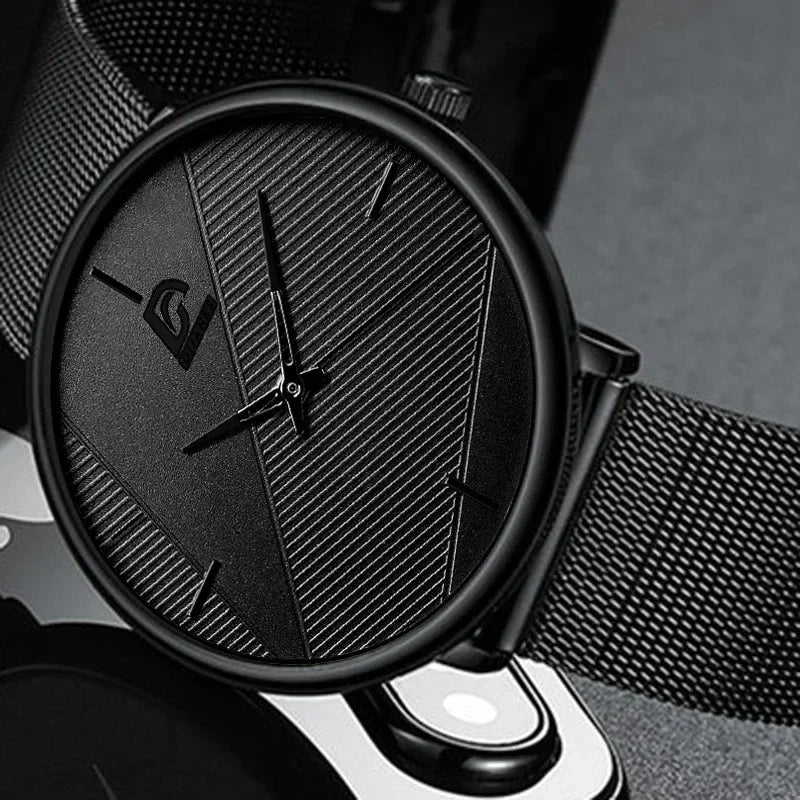 All-black minimalist men's wristwatch with a slim mesh strap and a textured, geometric dial.